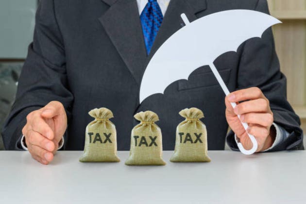 Taxpayer uses a hand and umbrella to protect tax bags