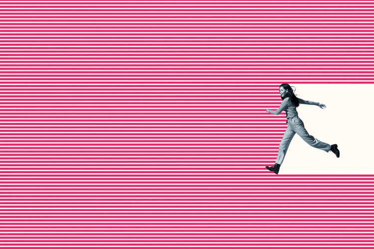 Smiling woman running on pink striped pattern