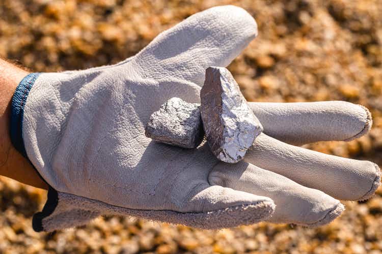 hand holding silver stones, silver ore. Gemstone mining concept