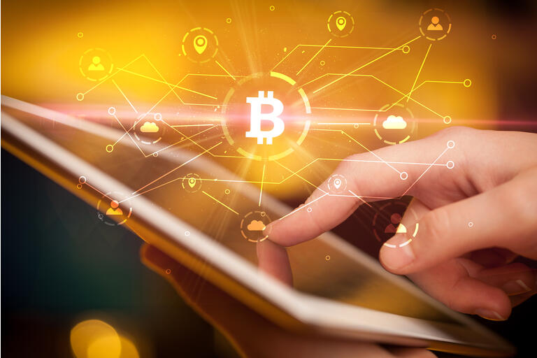 Hand using tablet with bitcoin link network and online concept