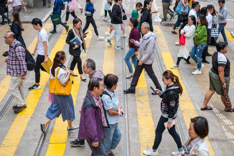 People crossing street in crowded shopping district of HongKong City
