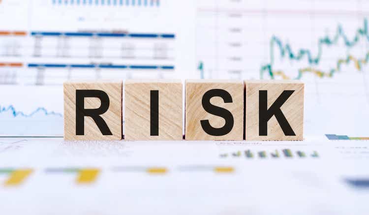 RISK word written on wooden cubes. Financial risk assessment, risk reward and portfolio risk management concept. Financial graphs and charts background