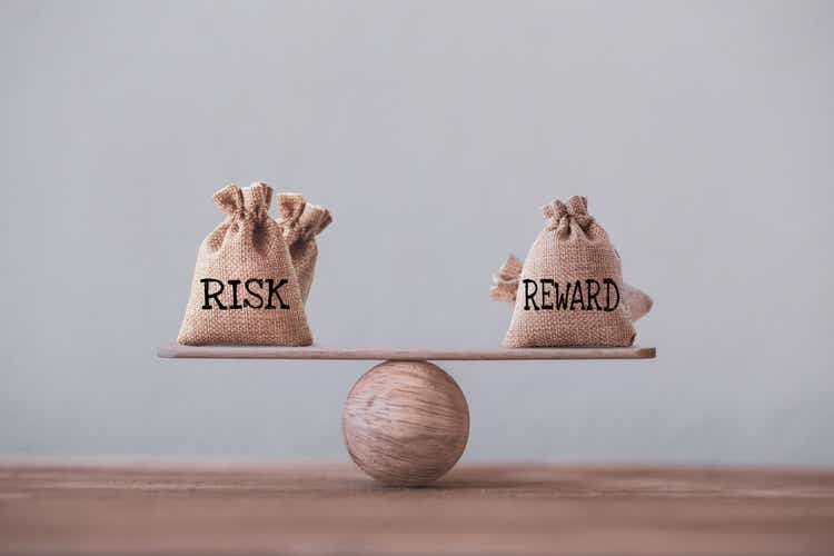 Bolsas de riesgo y recompensa en una escala de balanza básica en igual posición en la mesa de madera. concepto de gestión de riesgos, representa que los inversores utilizan una relación de recompensa de riesgo para comparar el rendimiento esperado de u
