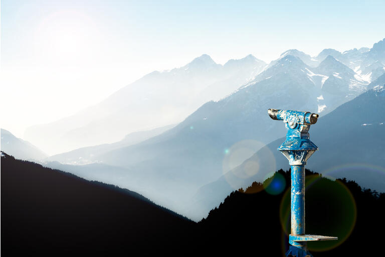 Public binoculars and Mountain Silhouettes at Sunrise. Foresight and vision for new business concepts and creative ideas. Alps, Trentino, South Tyrol, Italy.