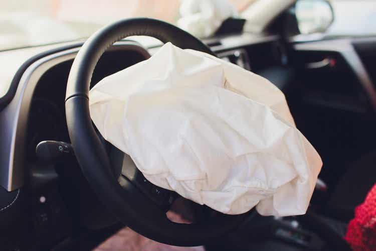 Interior of a automobile or car involved in a vehicle crash with a deployed steering column airbag.