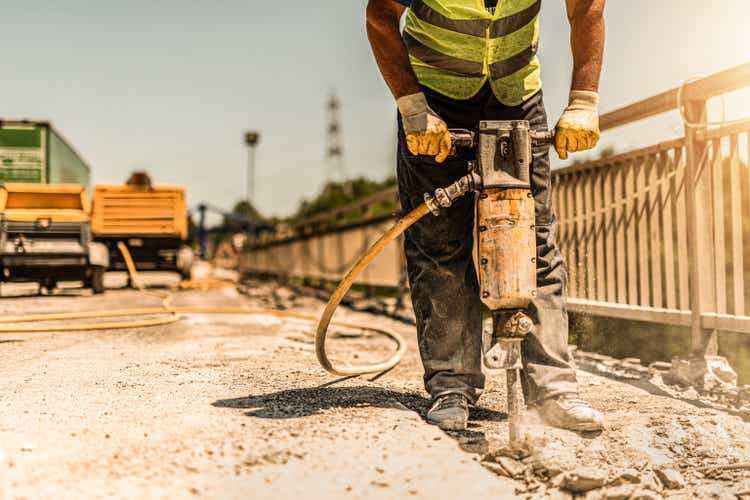 Nahaufnahme des Arbeiters mit Hammer und Reparatur Straße.