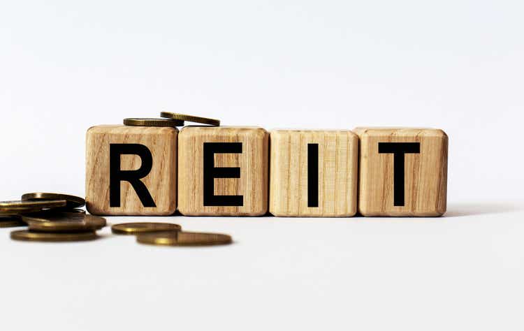 wooden cubes and REIT, coins, the concept of taxation, increase taxes and fees
