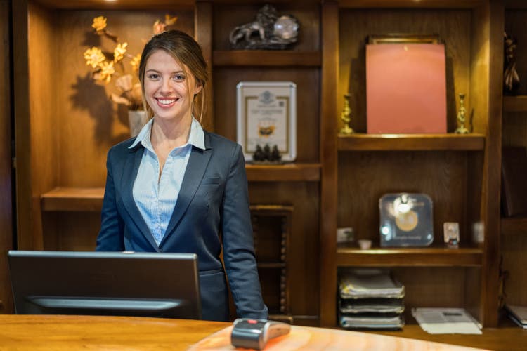 Hotel receptionist smiling at camera