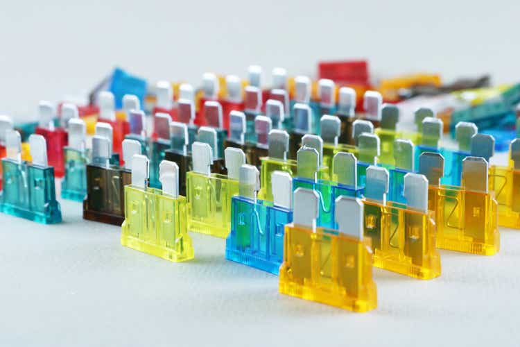 Car fuse. Fold colorful electric car fuses or circuit breakers isolated on beige background.