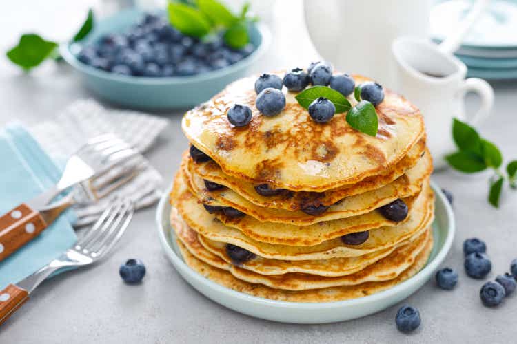 Blueberry pancakes with butter, maple syrup and fresh berries. American breakfast