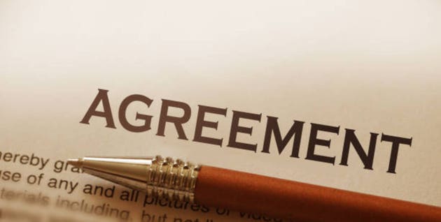 Close-up of word Agreement with silver pen. Selective focus