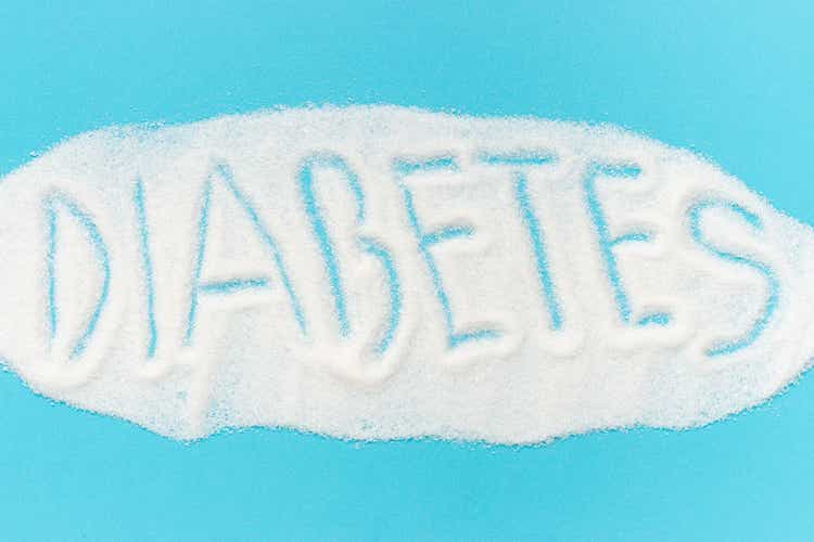 Word diabetes laid out from sugar isolated on a blue background