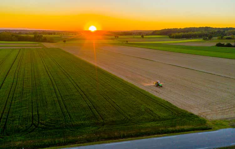 Tractor in field at sunrise