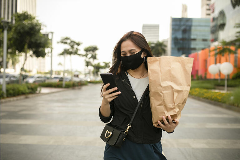 asian woman using phone when walking on the street