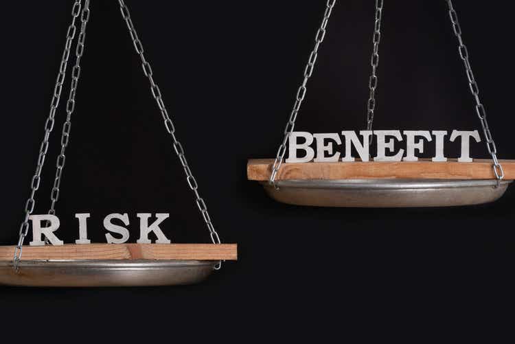 Risk and benefit reward concept. Scales on black background close up