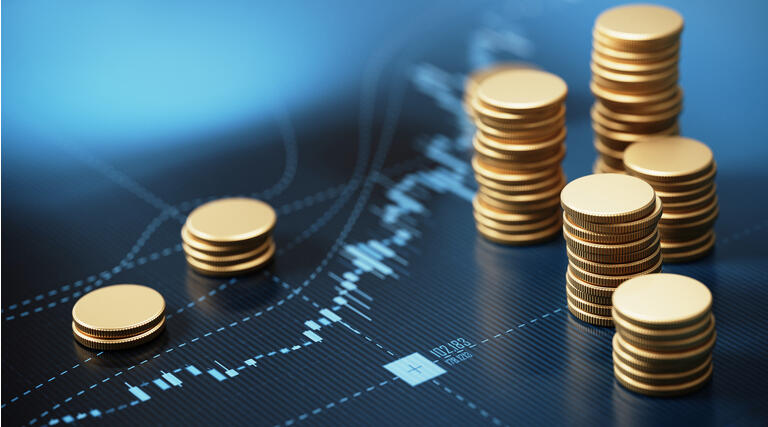 Coin Stacks Sitting on A Blue Financial Graph Background