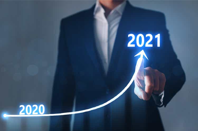Businessman pointing arrow graph corporate future growth year 2020 to 2021. Development to success and growing growth concept.