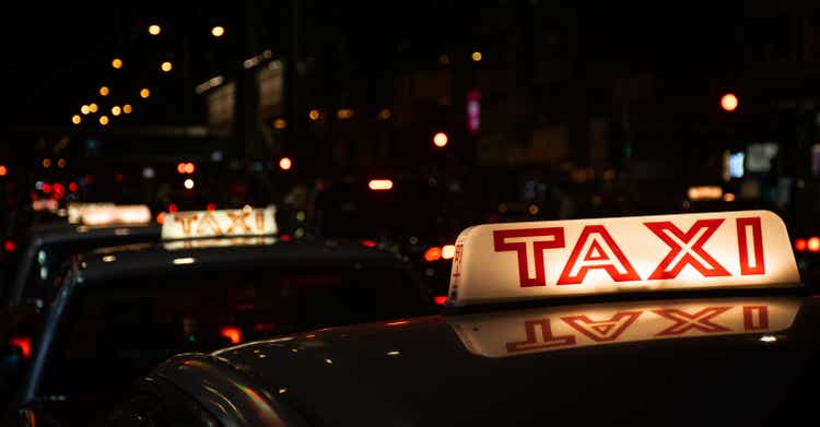 Taxi cab roof illuminated sign with blurry background at night