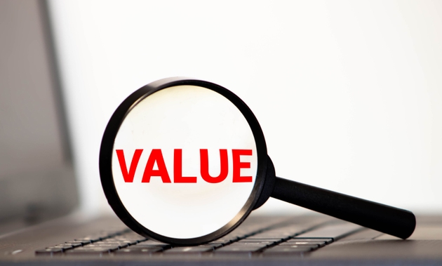 Hand Showing Value Word Through Magnifying Glass