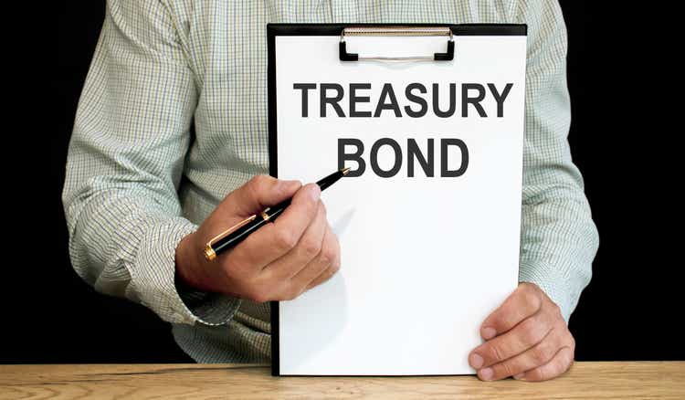 Treasury bonds word written on a piece of paper. A man holds it and points to the word with a pen