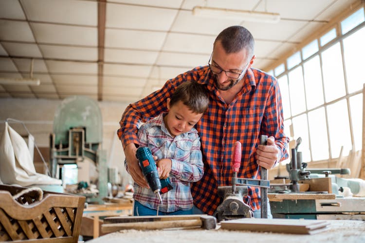 Family carpentry, woodwork and people concept. Woodcarving with father.