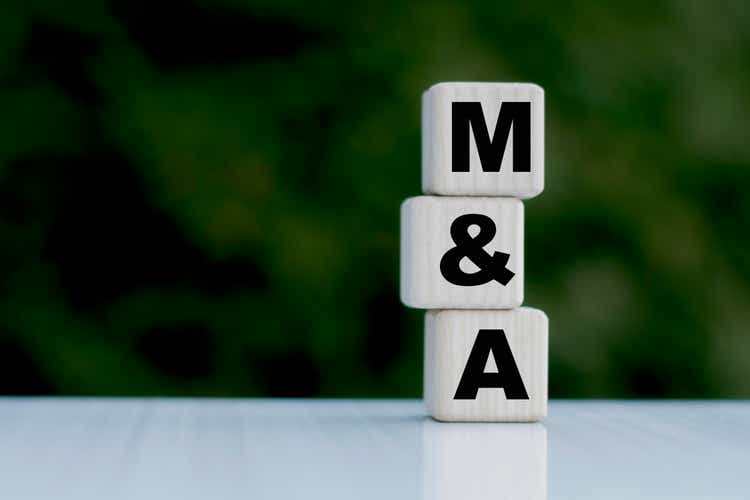 The concept of the word M&A on cubes on a beautiful green background