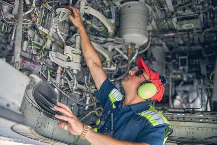 Man examining the underside of a plane