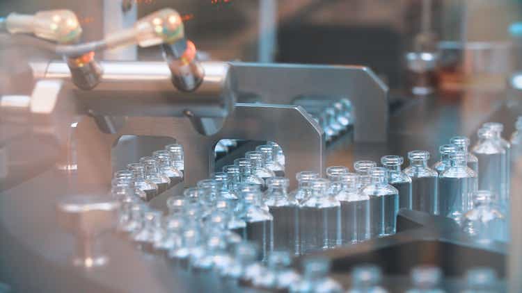 Glass bottles in production in the tray of an automatic liquid dispenser, a line for filling medicines against bacteria and viruses, antibiotics and vaccines