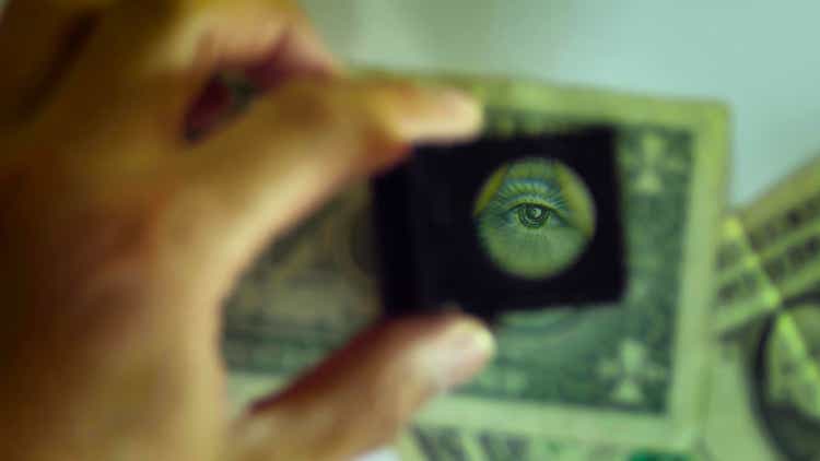 focus on a magnifying glass during the control of a one dollar bill