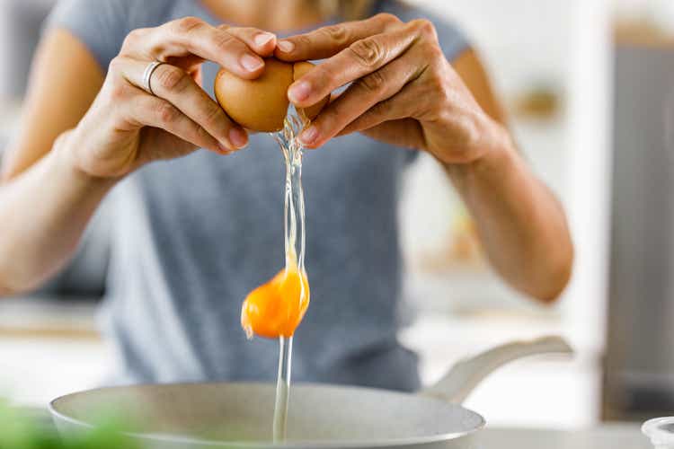 Close up of a woman cracking an egg.