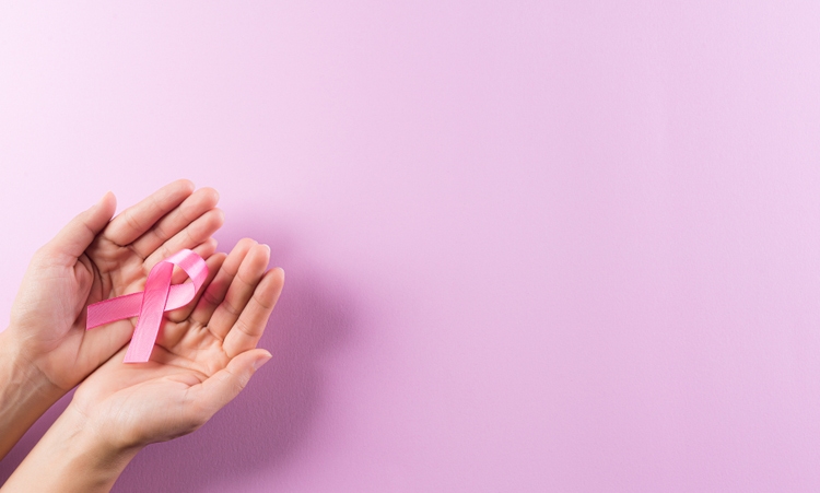 Healthcare and breast cancer awareness concept. Hands holding pink ribbons, Breast cancer awareness, symbolic bow color raising awareness on women"s breast tumor.