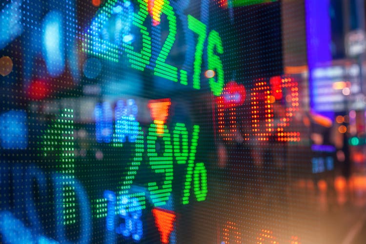 Display of Stock market quotes with city scene reflect on glass