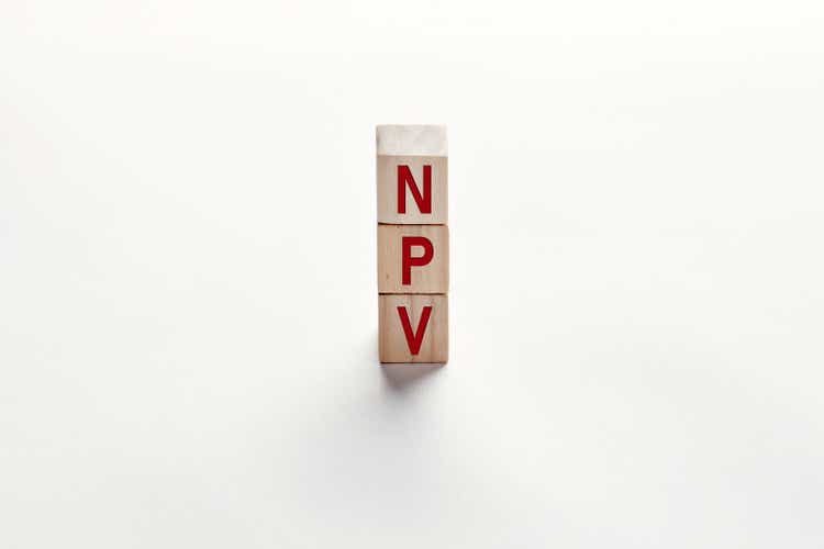 The word NPV net present value added tax on wooden cubes. Financial management and investment growth in business concept.