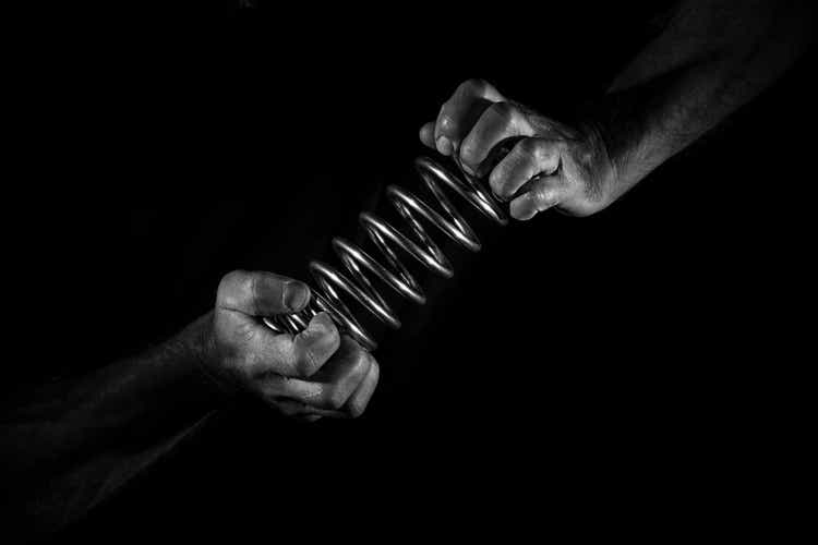 Hands holding the spiral steel spring