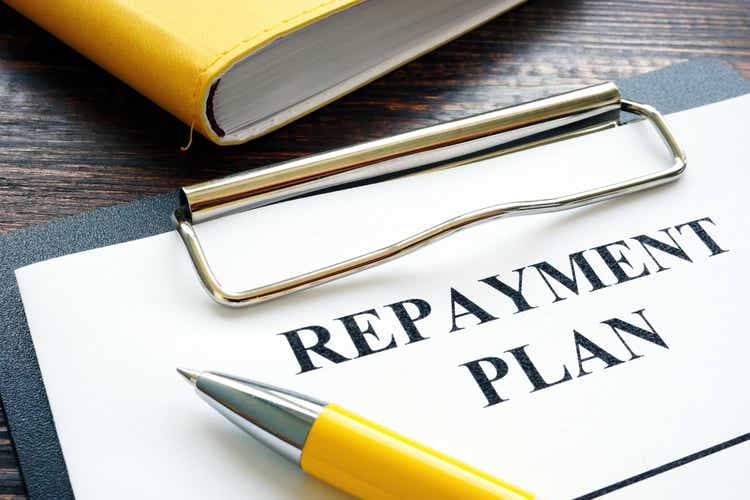 Repayment plan with clipboard and pen.