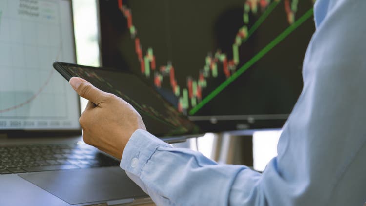 stock exchange trader working with graphs, diagrams on monitor in modern trading office.