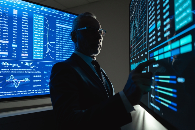 The businessman works on the big sensor display in the dark office