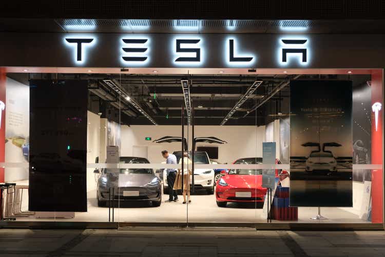 A Tesla storefront with customers inside at night in China