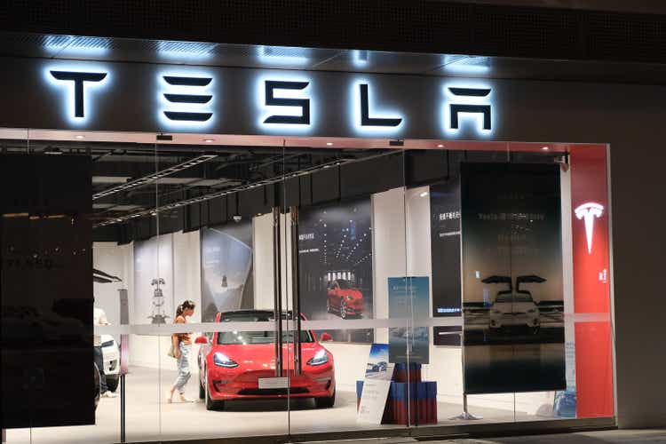 Tesla store with customers inside at night in Asia