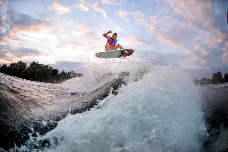 Active man engaged in extreme water sports on the surf style wakeboard.