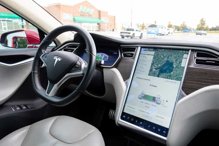View the passenger seat of a Tesla Model S parked and charged