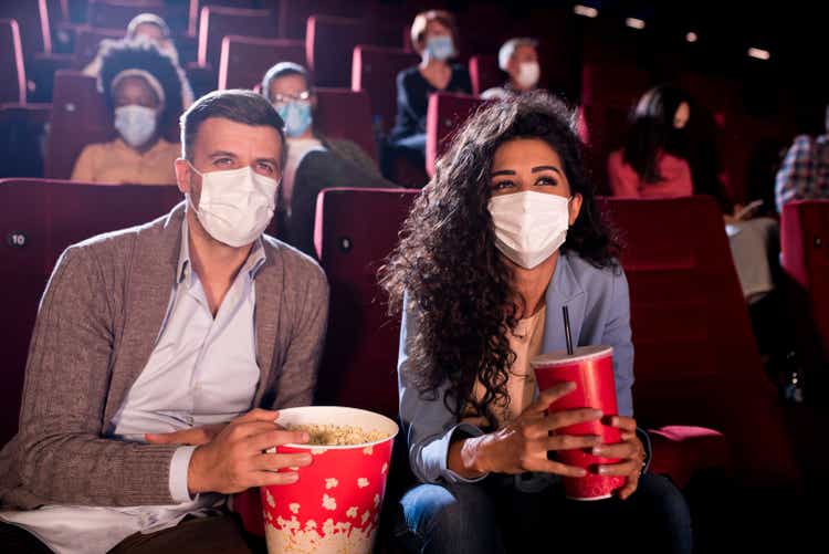 Happy couple wearing face masks at the cinema