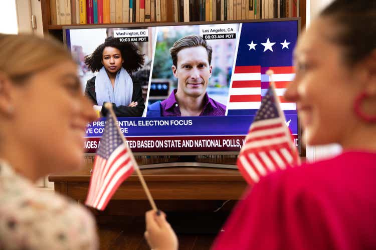 Women friends celebrating election results in front of TV