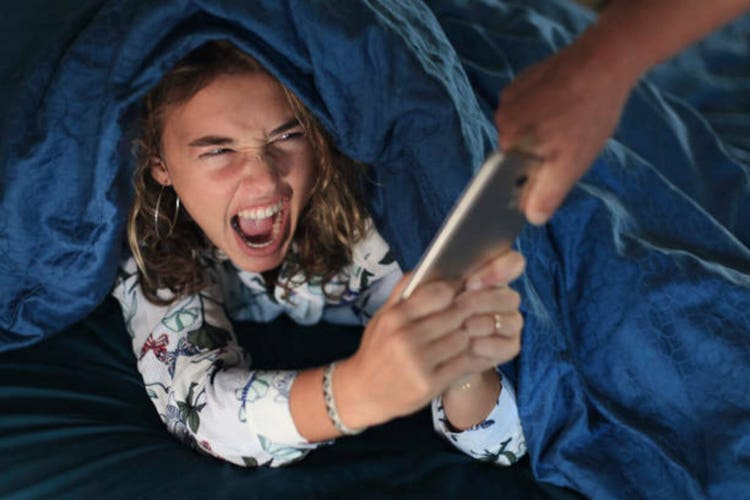 Teenage girl and everyday life. In bed with smartphone
