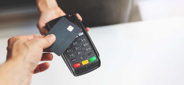 NFC contactless payment with credit card and POS terminal.  copy space