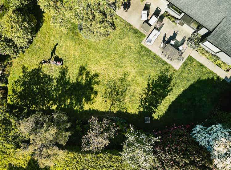 Aerial view of a man mowing grass in his backyard