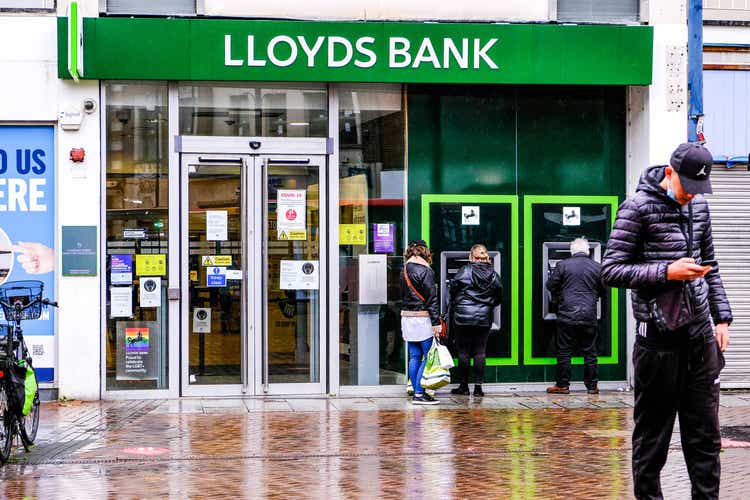 High Street Branch Of Lloyds Bank With People Walking Past During COVID-19