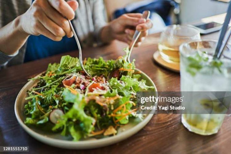 Japanese woman eating a vegan lunch at a vegan cafe