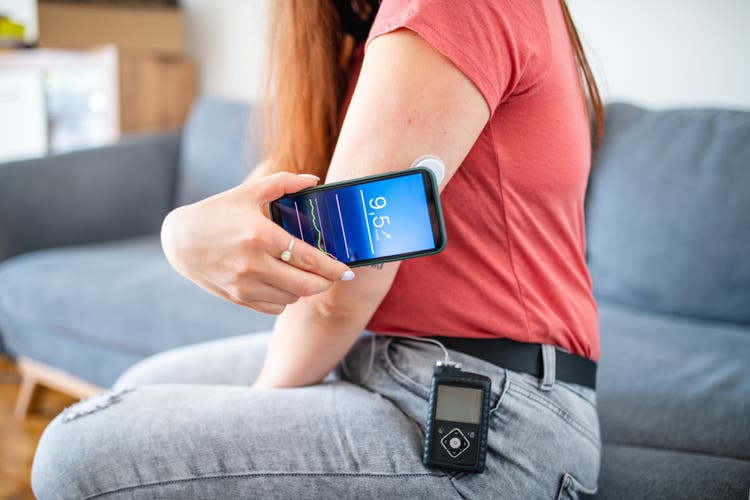 Young Woman with Type 1 Diabetes Swiping Sensor with Phone