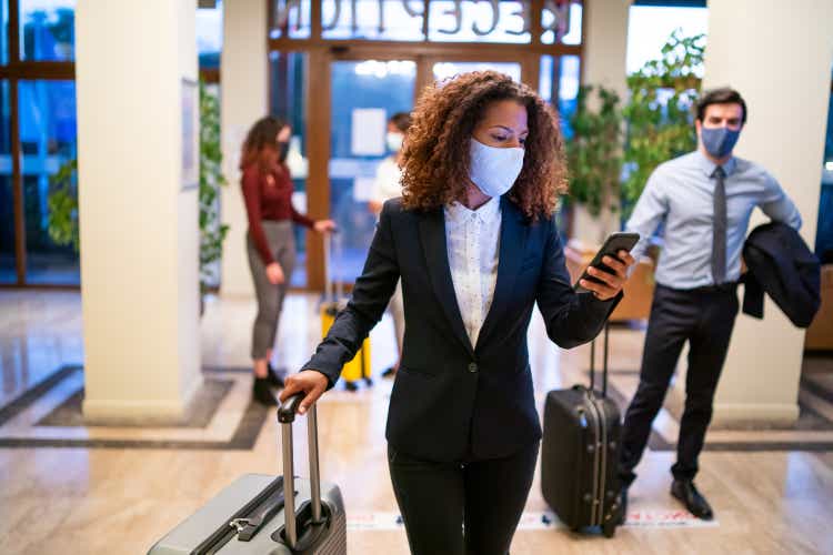 Hotel guests wearing a protective mask and maintaining social distance during COVID-19